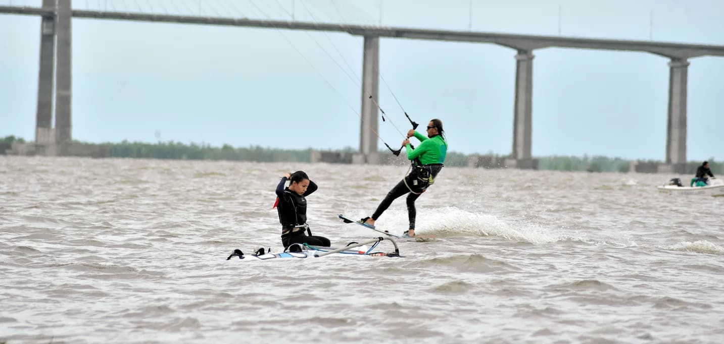 Kitesurf al atardecer sobre el Paraná, con el puente de Rosario al fondo
